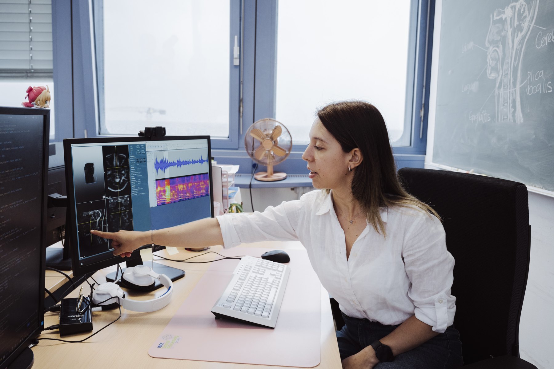 Paula A. Pérez-Toro pointing at speech and MRI analysis on a workstation screen